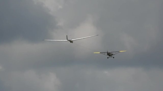 A glider is towed by a powered tug aircraft