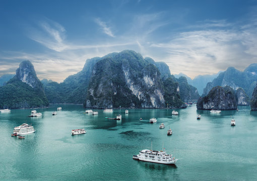 Tourist junks floating among limestone rocks at early morning in Ha Long Bay, South China Sea, Vietnam, Southeast Asia. Two images panorama