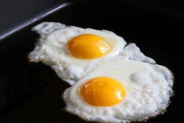 eggs sunnyside up closeup on grill