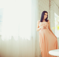 Gravid woman near the window