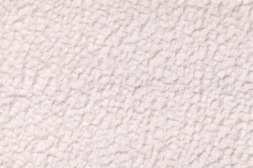 Light beige fluffy background of soft, fleecy cloth. Texture of textile closeup.