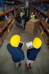 Warehouse manager and client standing