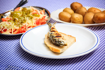 Grilled sardines with salad, bread and potato