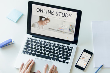 Hands working with a laptop on the white office desk with a mobile phone, a title online study on...