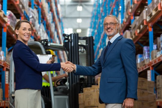 Warehouse manager shaking hands with client