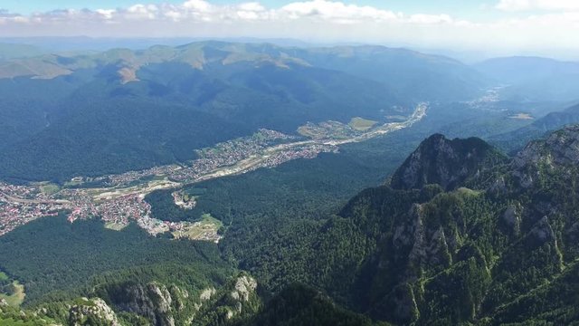 Tilt from Caraiman Peak to Bucegi city, aerial flight, Romania