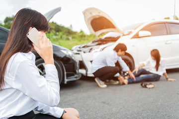 Car collision. driver man and woman examining damaged automobile cars after crash accident in city..