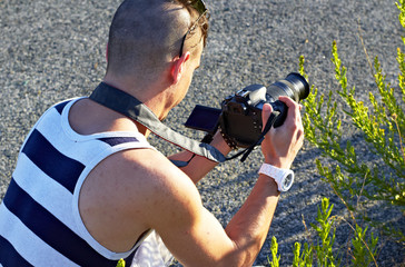 Young Man with reflex camera video recording