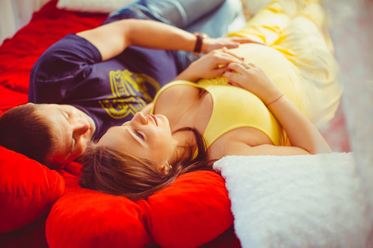 Young couple expecting a baby lying on the bed