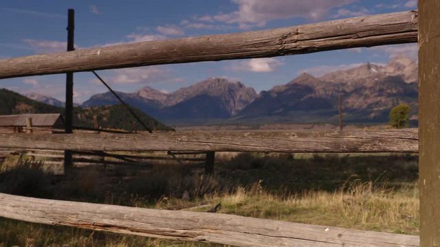 Panning shot of wooden fence and Teton Range Rocky Mountains