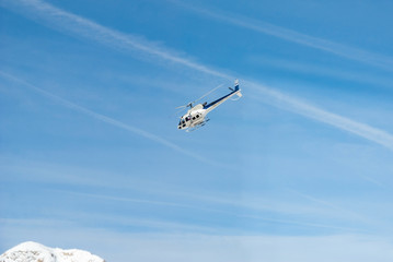 Mountain rescue emergency helicopter in flight, blue white