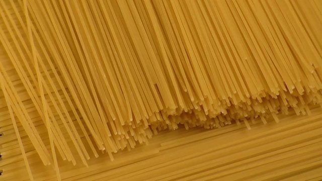 Raw yellow long spaghetti.Thin pasta arranged in rows. 
