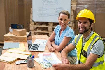 Warehouse managers and workers smiling in warehouse