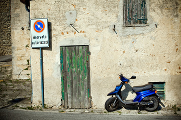 Blue scooter near the wall in Italy