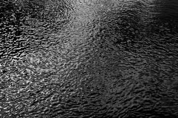 Water in river with small waves in black and white