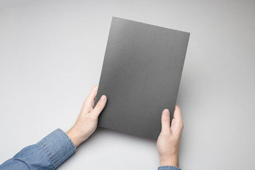 Hand is holding gray Notebook