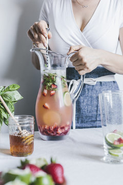 Woman mixing pitcher full of honey sweetened limeade