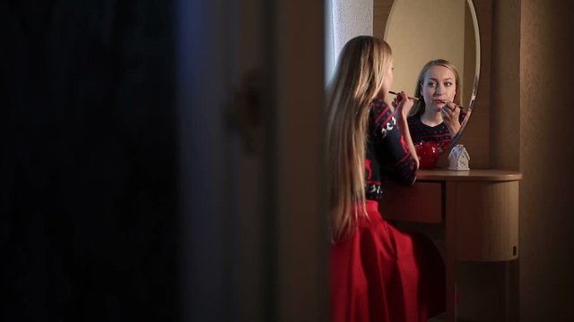 Sexy woman applying red lipstick on Christmas Eve