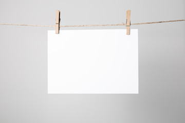 Blank poster hanging on rope with clothespins