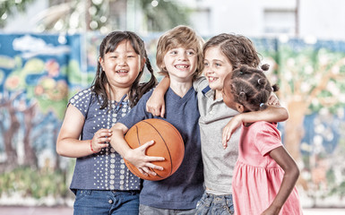 Elementary school children playing basketball at gym