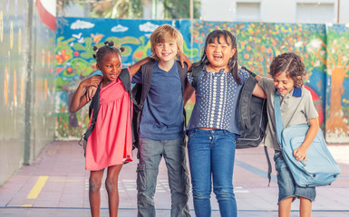 Happy multi ethnic classmates embracing in schoolyard, happiness