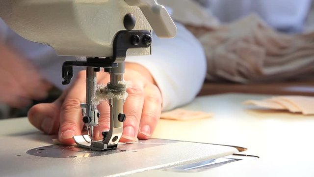 Seamstress at work by the sewing-machine