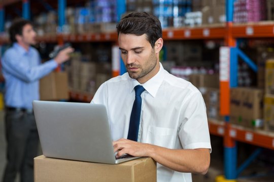 Warehouse manager working on laptop