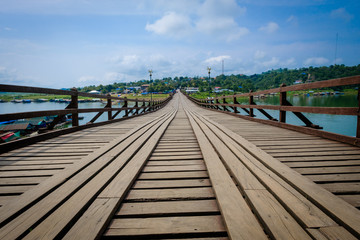 Fototapeta premium Wooden bridge that crosses the khao laem artificial lake, connecting the mon refugees village to sangkhlaburi village. made by hand. Sangkhaburi,Kanchaburi,Thailand.Photo taken on: October 14, 2016