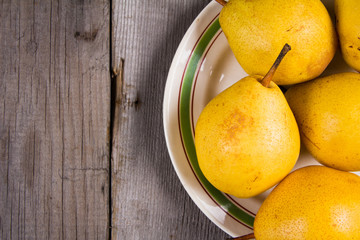 Fresh ripe organic yello pears on rustic wooden table, natural background, diet food.