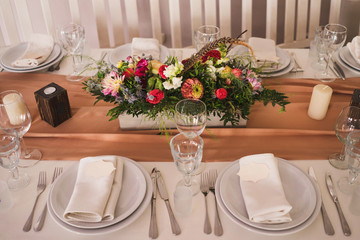 floral decoration and name cards on the plates on the table at wedding reception