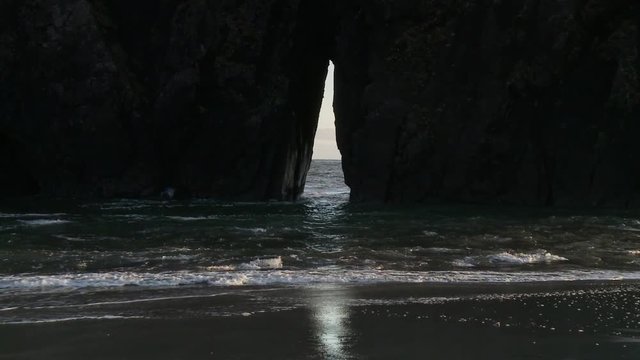 Zoom in shot of water flowing through hole from rock