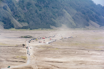 Landscape of Mount Bromo caldera filled with tourist vehicles