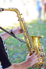 Hands of man playing the saxophone at outdoor