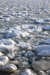 Fototapeta na wymiar Lumps of snow and ice frazil on the surface of the freezing rive