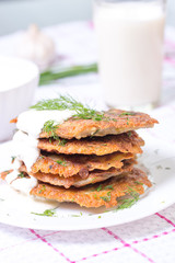 Delicious homemade potato pancakes on plate with sour cream, selective focus