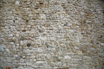 Old looking stone wall structured from variety of rocks