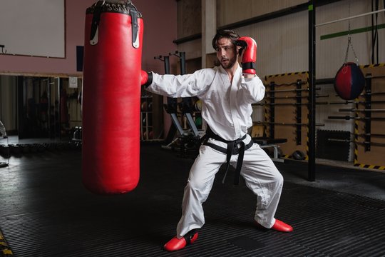 Man practicing karate with punching bag