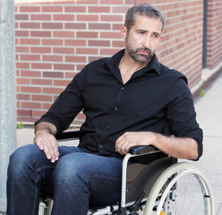 man sitting in wheelchair looking depressed