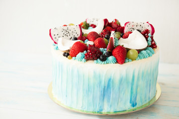 Beautiful cake with berries and fruit on a wooden table