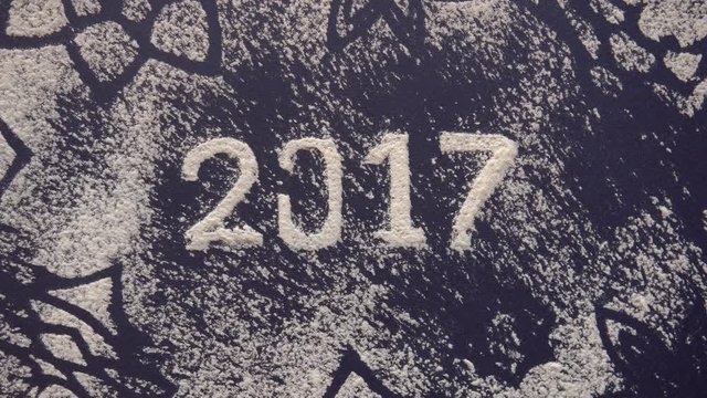 2017 new year written in flour on the dark background, top view, slow motion, 4K, snow imitation, snowstorm