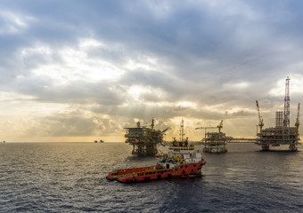 Obraz premium Anchor handling tugboat approaching oil rig
