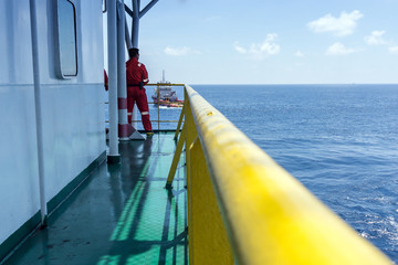 Offshore worker monitoring anchor handling operations from a construction barge at offshore...