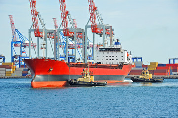 Naklejka premium Tugboat assisting bulk cargo ship