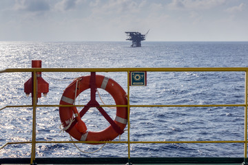Life ring and emergency beacon EPIRB on a handrail of construction barge at oilfield Malaysia