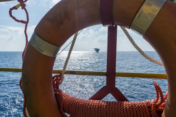 Oilrig platform viewed through lifebouy on a vessel