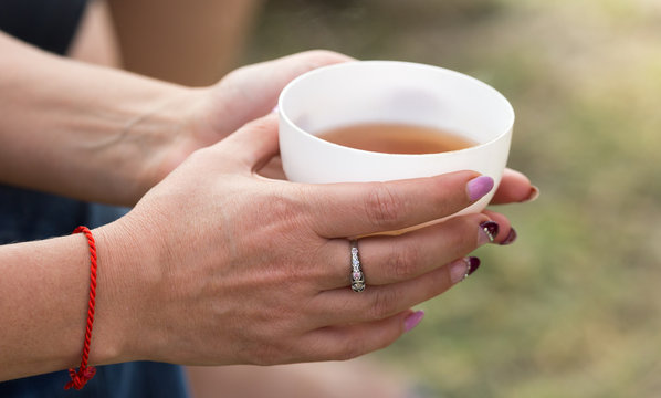 tea in the woman's hand on nature