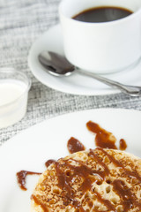 Close up of a crumpet covered in chocolate sauce