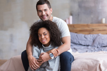 Smiling couple sitting in the bedroom together