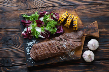 Grilled machete steak with mix of salad and corn, above view