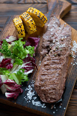 Barbecued machete beefsteak with corn and salad mix, close-up